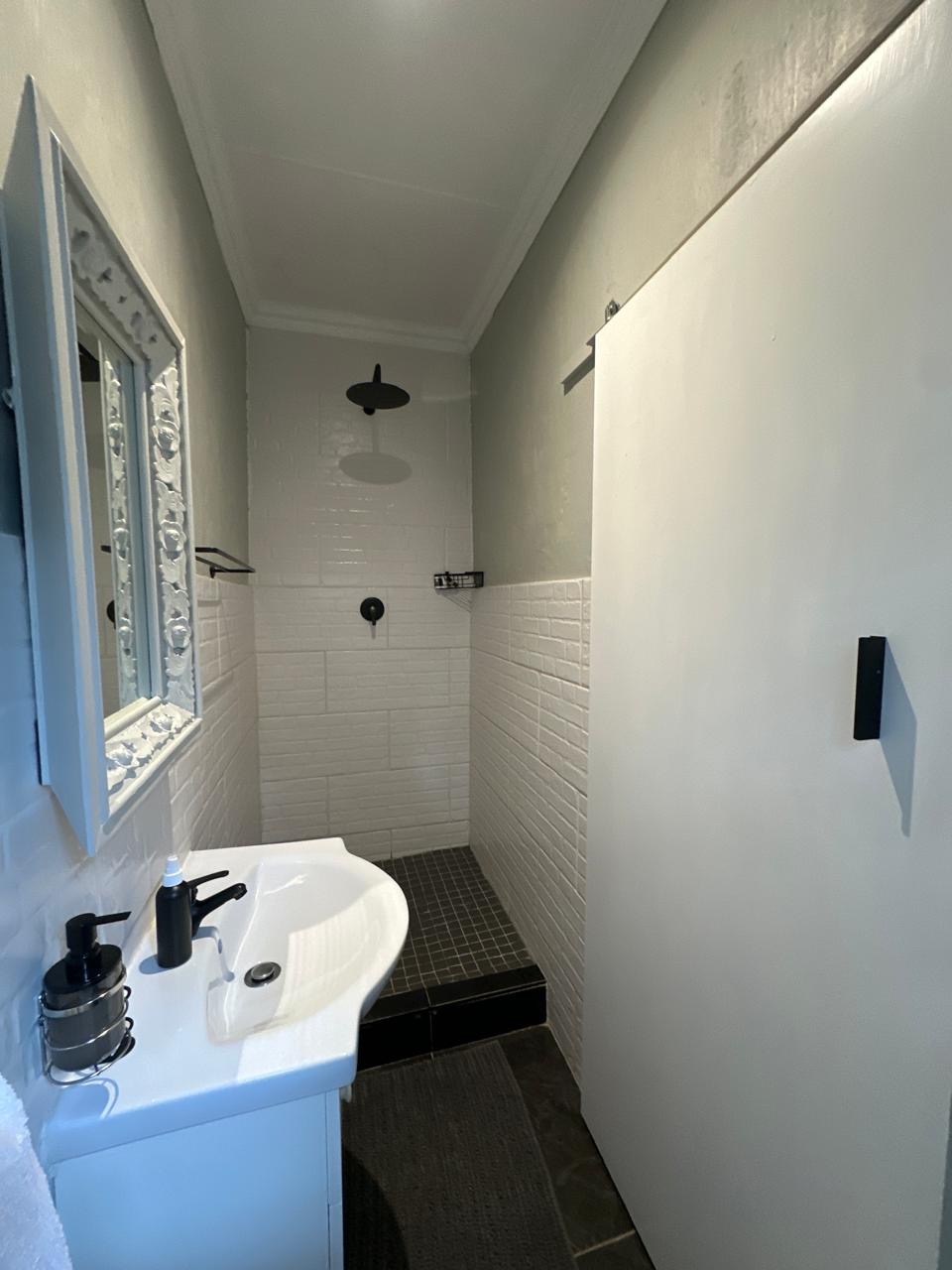 Room 8 shower and basin with classic white tiling