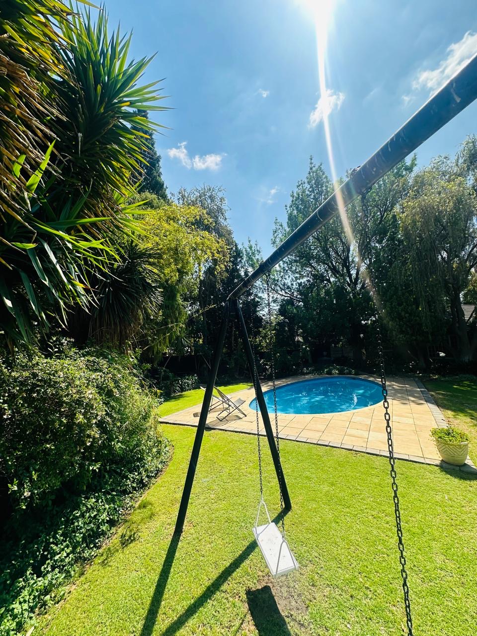 Garden swing overlooking the swimming pool at Cherry Nest