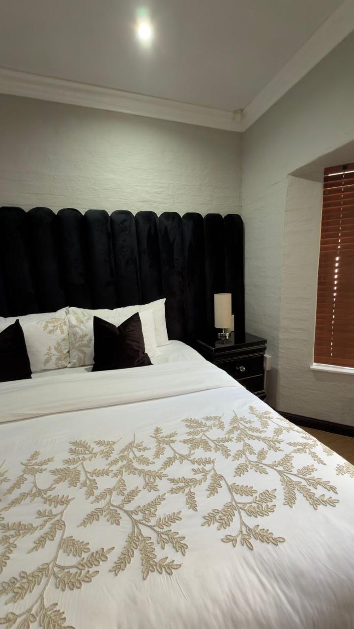 Embroidered bedding and velvet headboard detail in Room 7