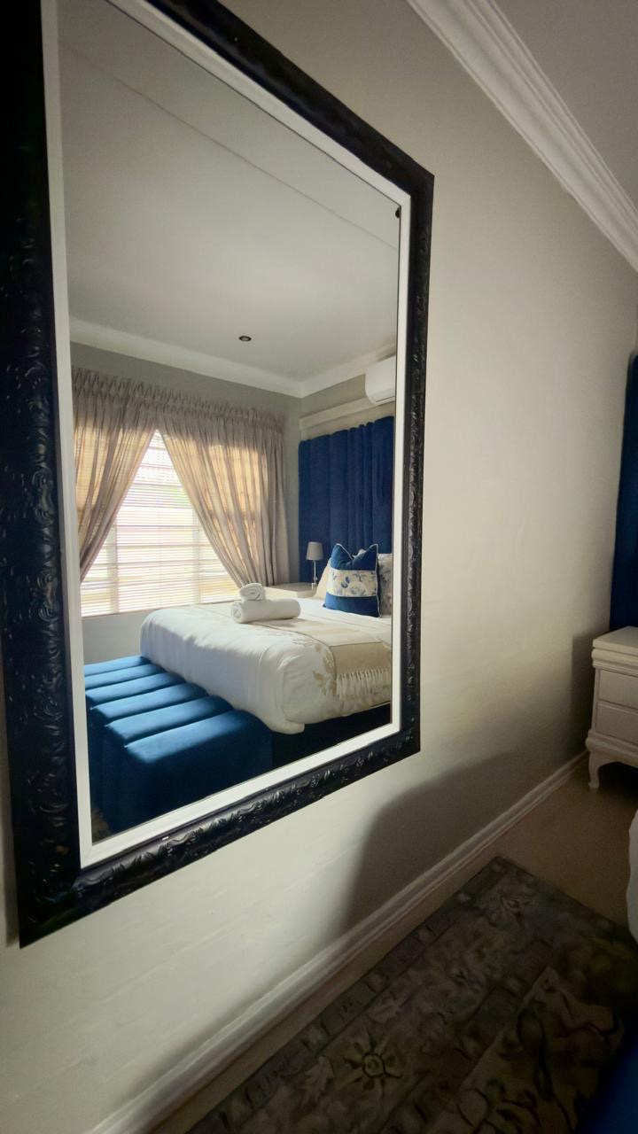 Room 8 bedroom reflected in an ornate mirror with blue accents