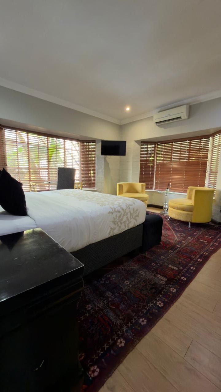 Room 7 deluxe queen room with seating corner and wooden shutters