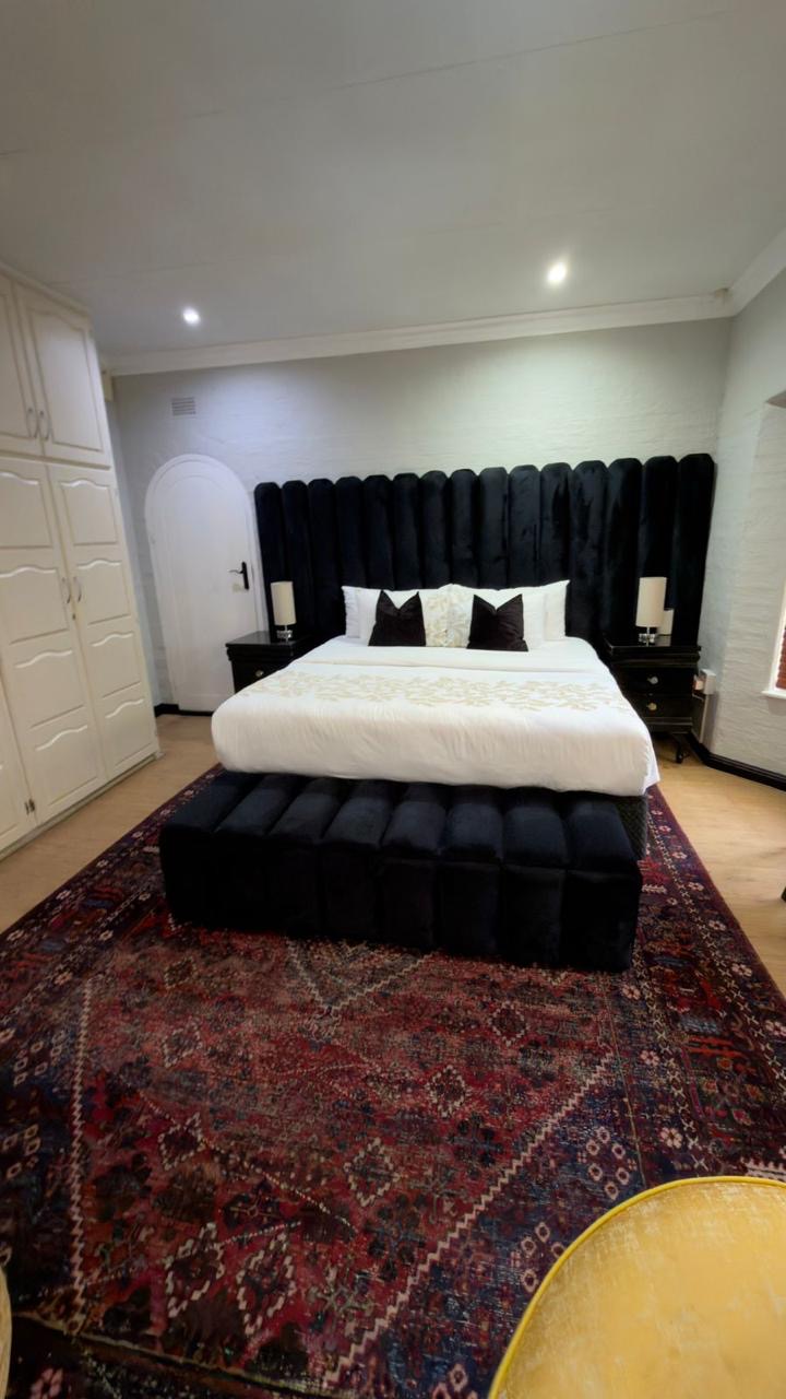 Room 7 with dressed bed, velvet headboard and Persian rug
