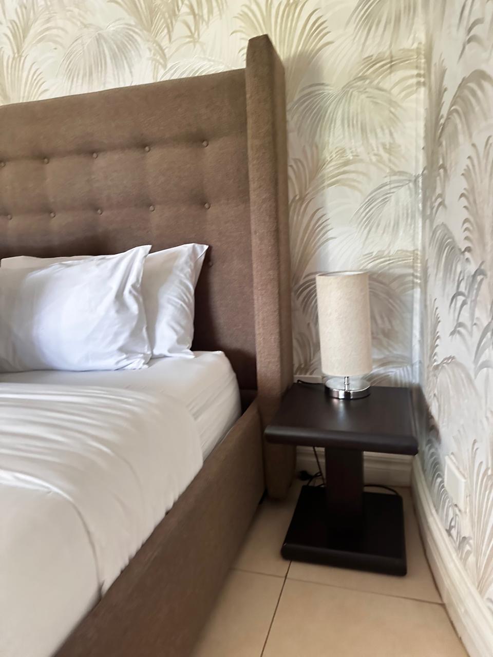 Room 1 bedside detail with upholstered headboard