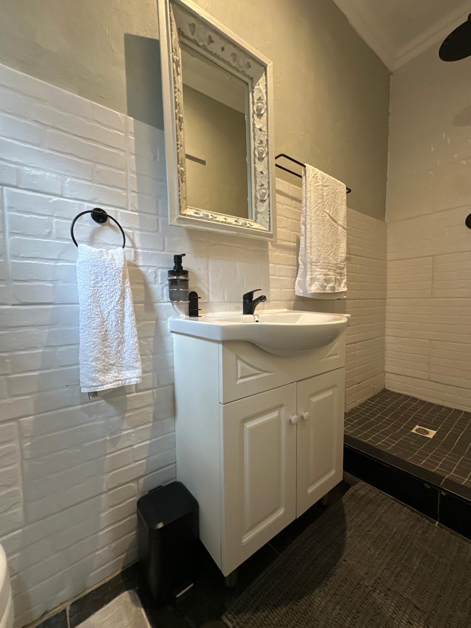 Room 8 bathroom with white vanity and walk-in shower