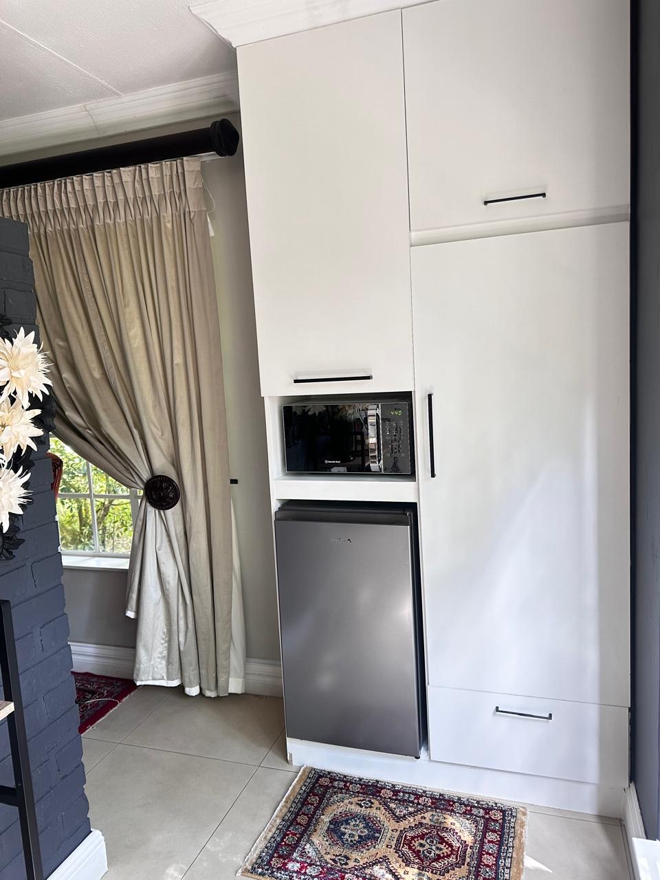 Room 1 built-in cabinetry with microwave and bar fridge