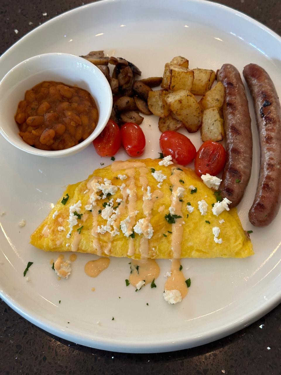 Cooked breakfast with omelette, sausage, baked beans and roast potatoes